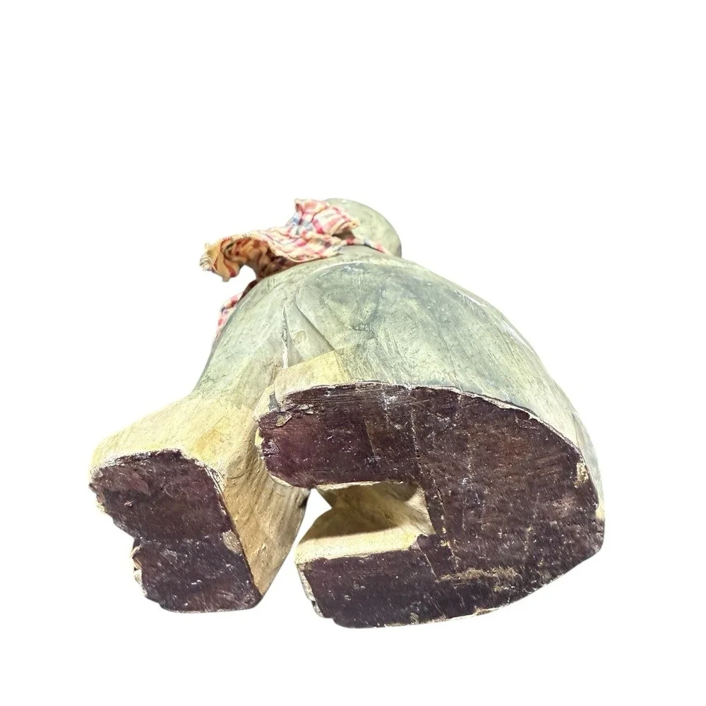 hand-carved wooden cat figurine with a painted finish and a plaid cloth scarf.